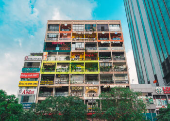 View from below of Saigonese 42 Nguyen Hue Coffee Apartment Building, a colourful complex filled with cafés